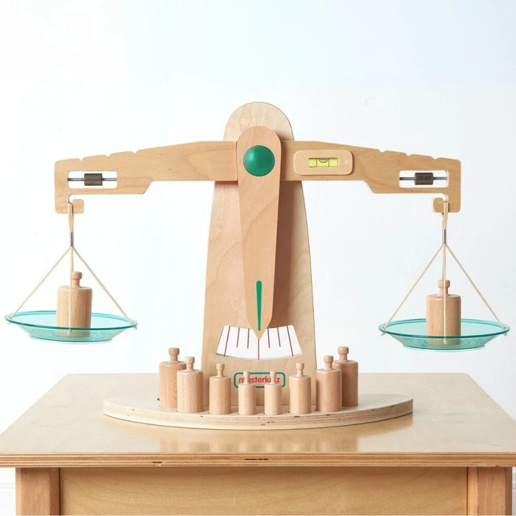 Dziecko bawiące się drewnianą wagą szalkową Masterkidz podczas nauki zasad równowagi