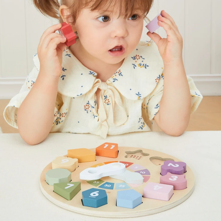 Ręka dziecka obracająca wskazówki zegara sorter kształtów Viga Toys