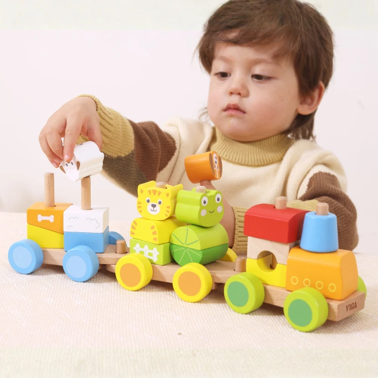 Dziecko bawiące się drewnianym pociągiem do układania Viga Toys na podłodze