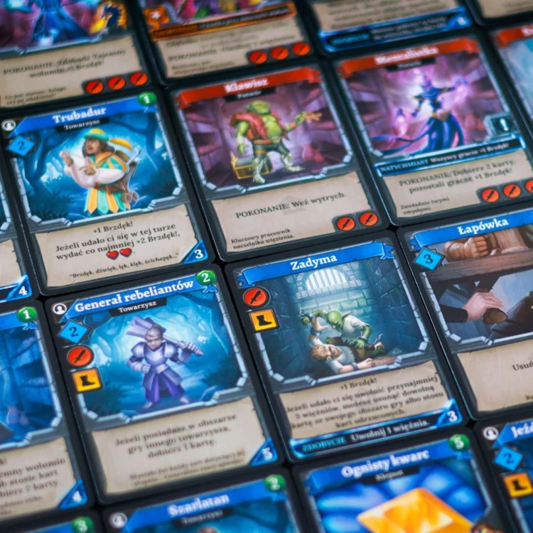 Widok na elementy gry Brzdęk! Katakumby Lucrum Games z detalami kart i kafli
