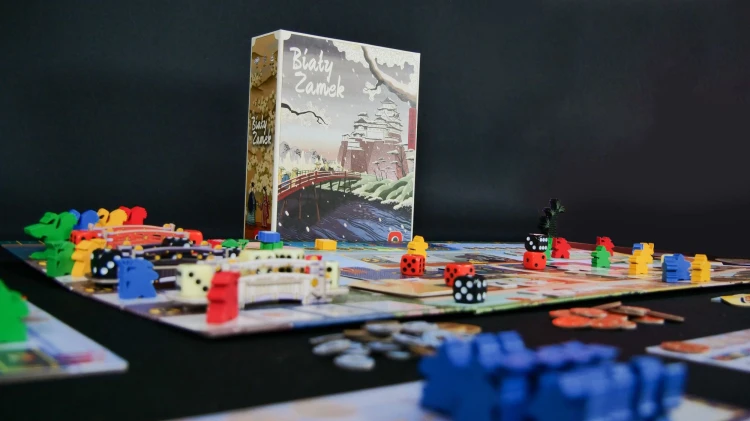 Karty, kafelki i kości gry planszowej Biały Zamek wydawnictwa Portal Games