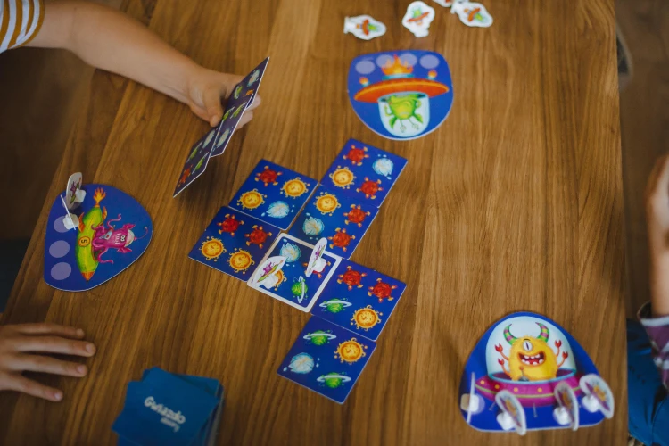 Zbliżenie na pionki i karty w grze edukacyjnej Gwiazdozbiory KUKURYKU