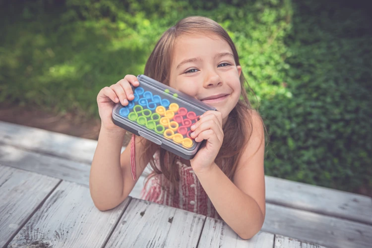 Kolorowe elementy gry IQ Twist IUVI Games rozłożone obok planszy