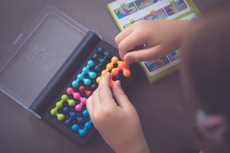 Elementy układanki 3D gry IQ Fit IUVI Games ułożone na planszy do gry