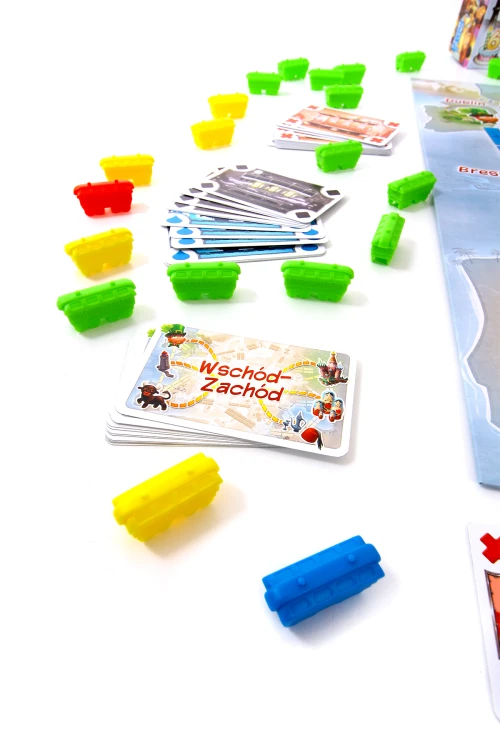 Elementy gry Wsiąść do Pociągu: Pierwsza podróż w tym karty biletów i plastikowe wagoniki dla dzieci