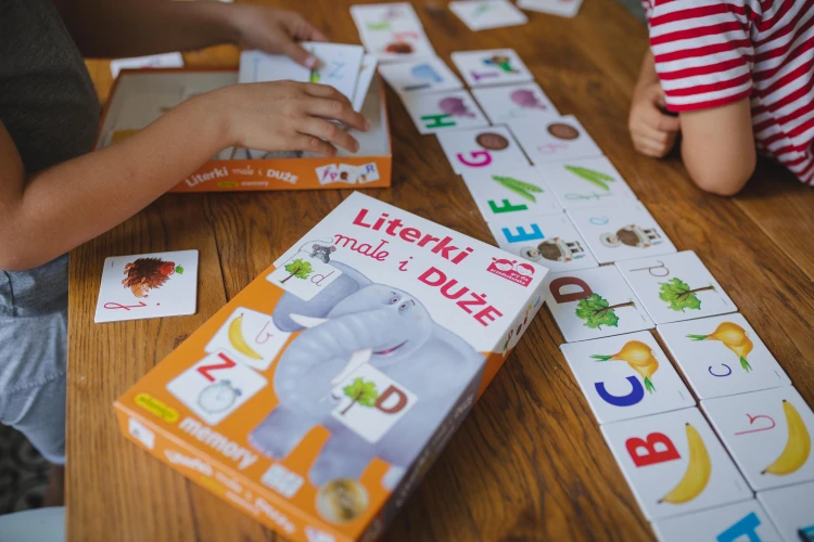 Widok na rozłożone tafelki edukacyjnej gry memory ADAMIGO Literki małe i duże