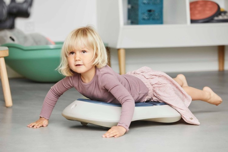 Deskorolka Floor Surfer ustawiona na podłodze; pokazane zastosowanie w domu i na sali zabaw z naciskiem na stabilność siedzenia
