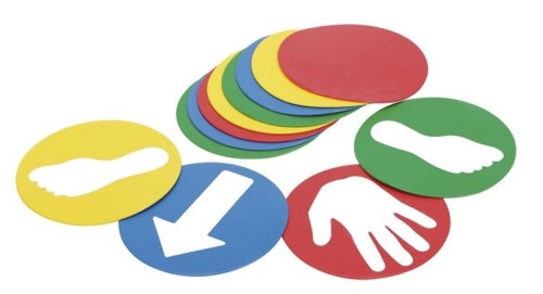 Kompozycja 12 dysków Educo Disks ułożonych w rzędzie, widoczne białe naklejki z motywami rąk, stóp i strzałek, idealne do ćwiczeń orientacji