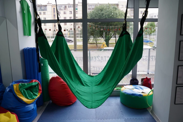 Detal zaczepu trampoliny sensorycznej: czarna taśma wzmacniająca przy haftowanym punkcie montażowym, widoczna struktura tkaniny