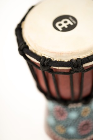 Zbliżenie na ręcznie malowany korpus mini bębna djembe z motywem kwiatowym
