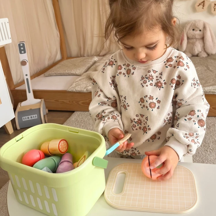 Kolorowe drewniane owoce i warzywa TOOKY TOY rozłożone na stole, widok z góry pokazujący kształty i malowanie