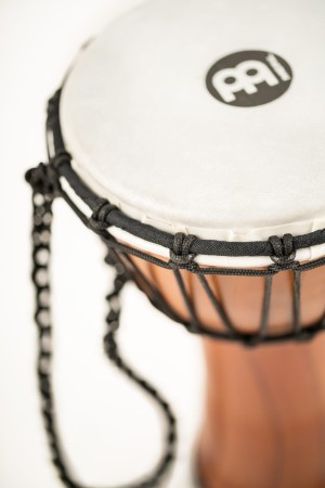 Bęben djembe 7 cali w kolorze Twisted Amber na tle drewnianym, syntetyczny naciąg
