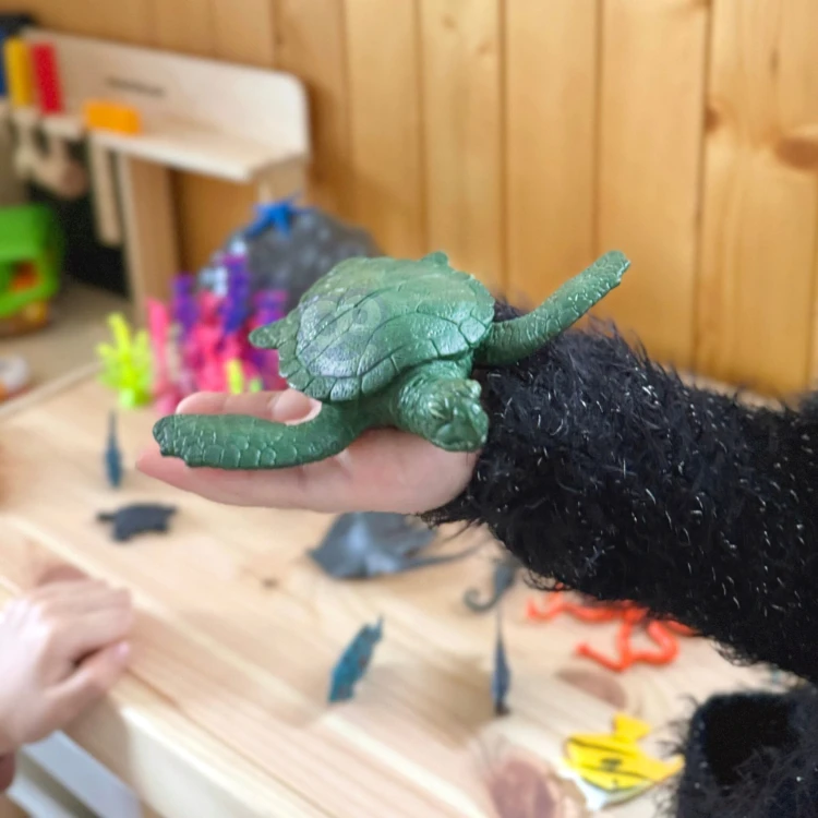 Kolorowe figurki morskich zwierząt WOOPIE ustawione na macie scenograficznej, widoczne szczegóły malowania