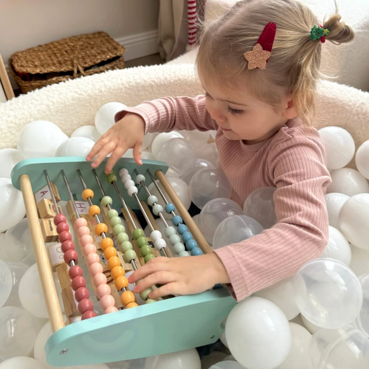 Klocki z literami ukazane z góry na dwustronnym liczydle — TOOKY TOY podkreśla edukacyjny charakter zabawki