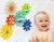 Dziecko bawi się zębatką kąpielową WOOPIE BABY na gładkiej powierzchni w wannie, naturalna scena zabawy