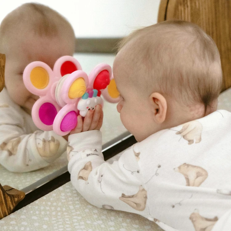 Trzy różowe spinnery Pop-it WOOPIE BABY ułożone obok siebie, widoczne wzory gwiazdki, chmurki i jednorożca