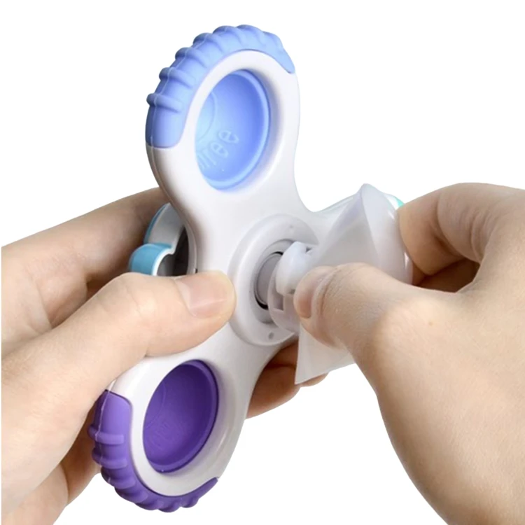 Kolorowy spinner WOOPIE BABY w kształcie UFO — widok na obrotowy element i przyssawkę