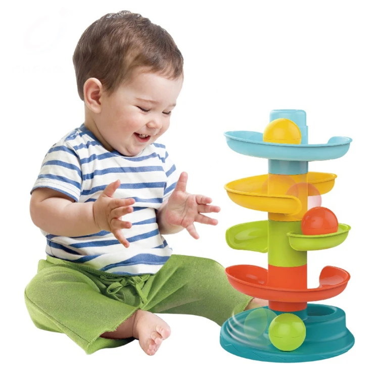 Dziecko bawi się kulodromem Spirala WOOPIE BABY - zabawa na stole z widocznymi pięcioma elementami i trzema kulkami