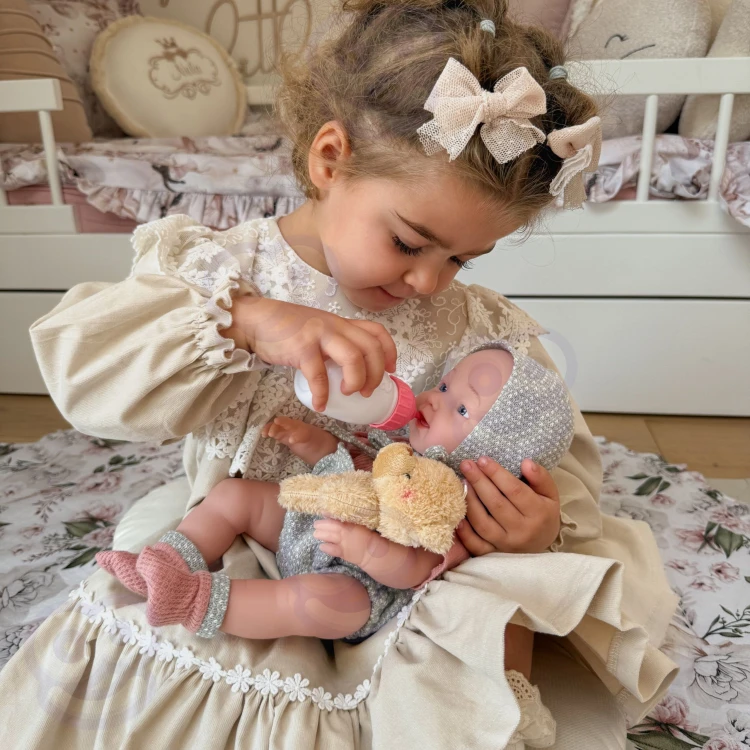 Lalka WOOPIE ROYAL w pozie leżącej — ubranko z misiem i akcenty materiałowe widoczne z góry