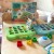 Opakowanie i elementy układanki Montessori Dinozaur — widoczny komplet do zabawy WOOPIE