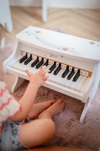 Zbliżenie na klawiaturę pianina CLASSIC WORLD — białe i czarne klawisze oraz detale drewna