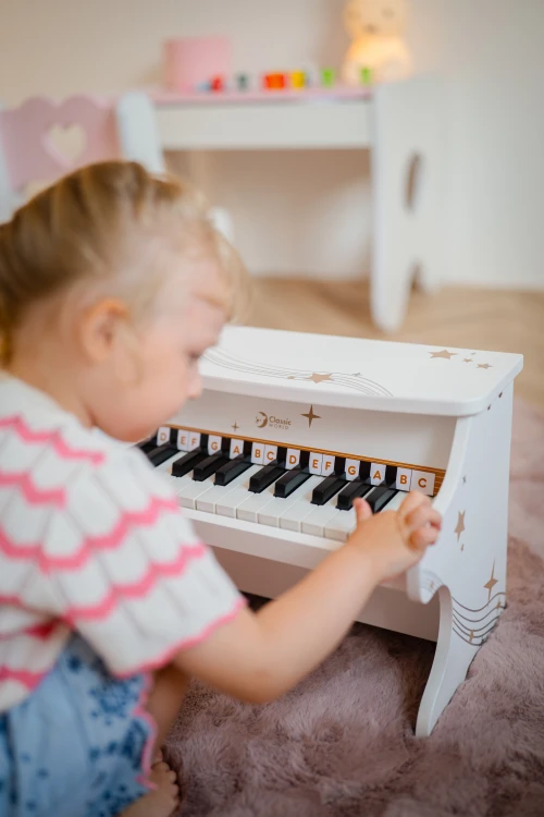 Pianino CLASSIC WORLD ustawione w pokoju dziecięcym — skala i proporcje obok zabawkowych akcesoriów
