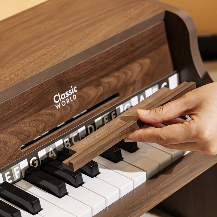 Pianino CLASSIC WORLD widziane z góry — układ klawiszy i książeczka do nauki ustawiona obok