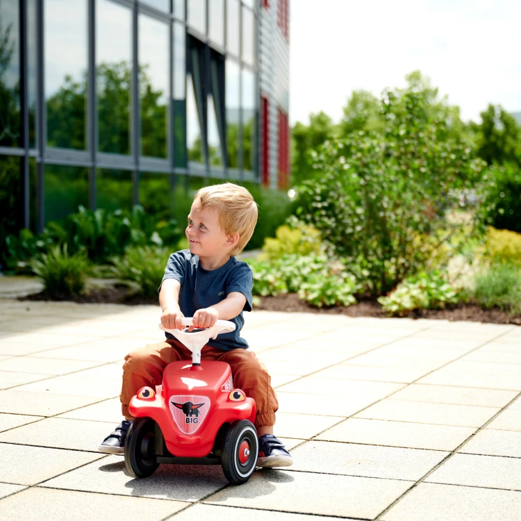 Zbliżenie na przednie koła jeździka Bobby Car — mechanizm skrętu i sposób mocowania osi