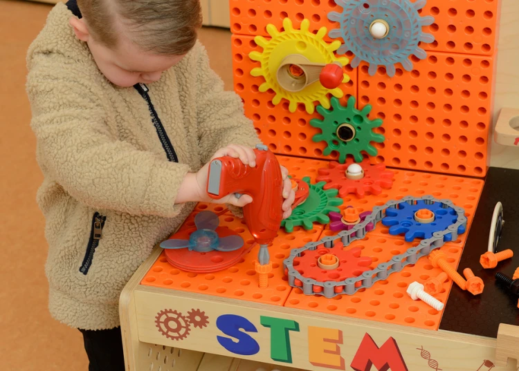 Detal narzędzi MASTERKIDZ — drewniany młotek i klucze ustawione na blacie warsztatu