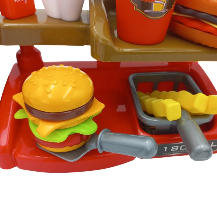 Scena zabawy z WOOPIE Fast Food XXL — dziecko obsługuje kasę i nalewa napój z dystrybutora podczas zabawy