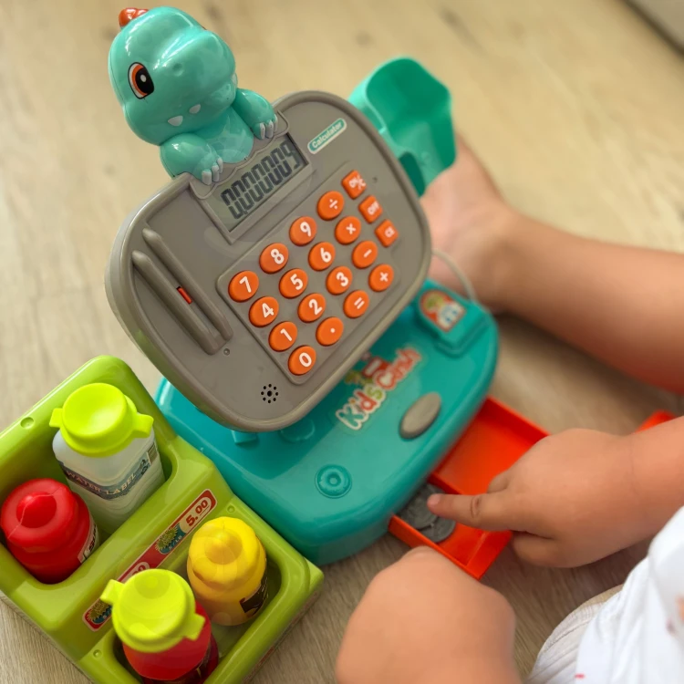 Zbliżenie ozdobnego motywu DINO na przedniej ściance kasy WOOPIE — widoczne detale grafiki i kolorystyki