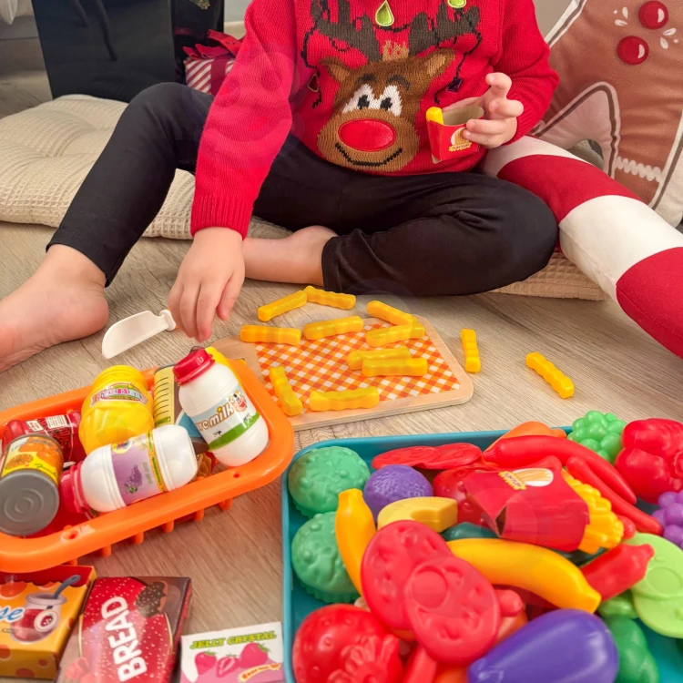 Zbliżenie na plastikowe owoce WOOPIE — kolorowe jabłka, banany i marchewki z realistycznymi detalami.