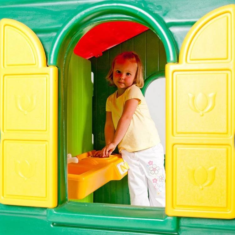 Detal wejścia Little Tikes domek ogrodowy — zbliżenie na drzwi i dekoracyjne okienko przy wejściu