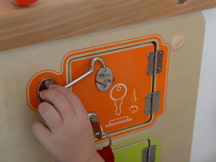 Pełne ujęcie planszy z różnymi zamkami i zatrzaskami — tablica manipulacyjna MASTERKIDZ w całości
