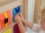 Perspektywa boczna tablicy manipulacyjnej MASTERKIDZ — widoczne kieszenie i krawędzie drewnianej ramy
