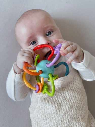 Szczegół zbliżenia na miękkie silikonowe elementy i koraliki grzechotki WOOPIE BABY, widoczna faktura