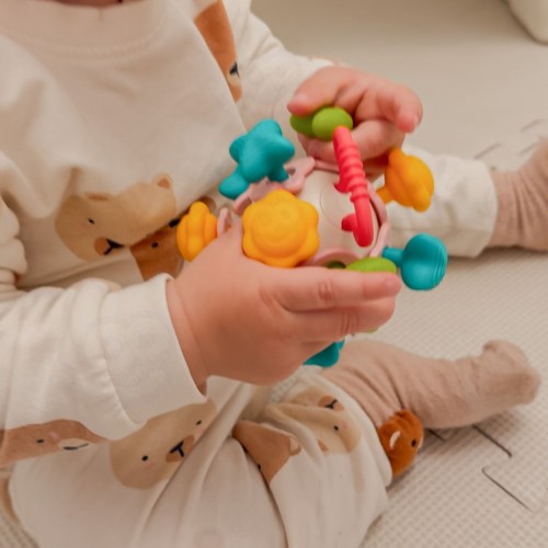Zbliżenie na gryzak i powierzchnię miękkiej grzechotki - detal faktur i uchwytu WOOPIE BABY