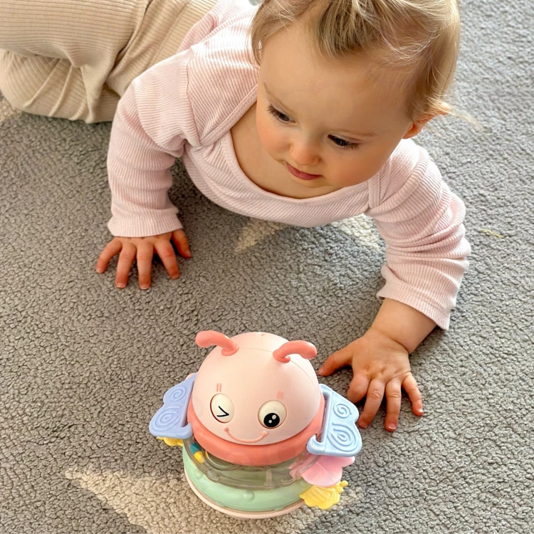 Ręka dorosłego trzyma wańkę — ergonomiczny chwyt, grzechotka i gryzak WOOPIE Baby