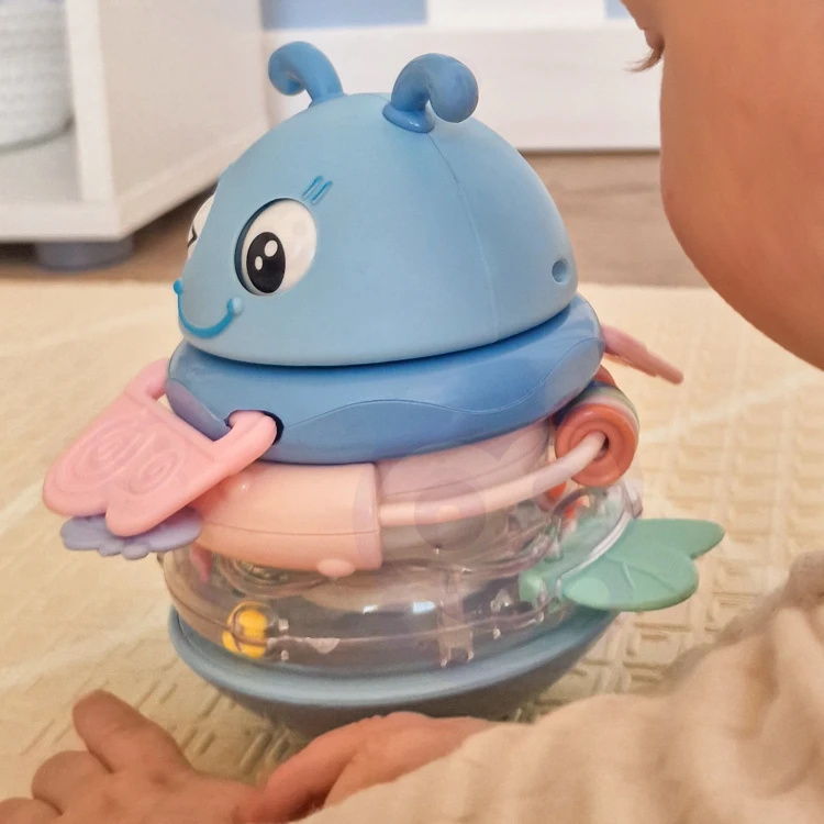 Zabawka trzymana w małej dłoni niemowlaka — grzechotka i gryzak WOOPIE Baby w naturalnym ujęciu