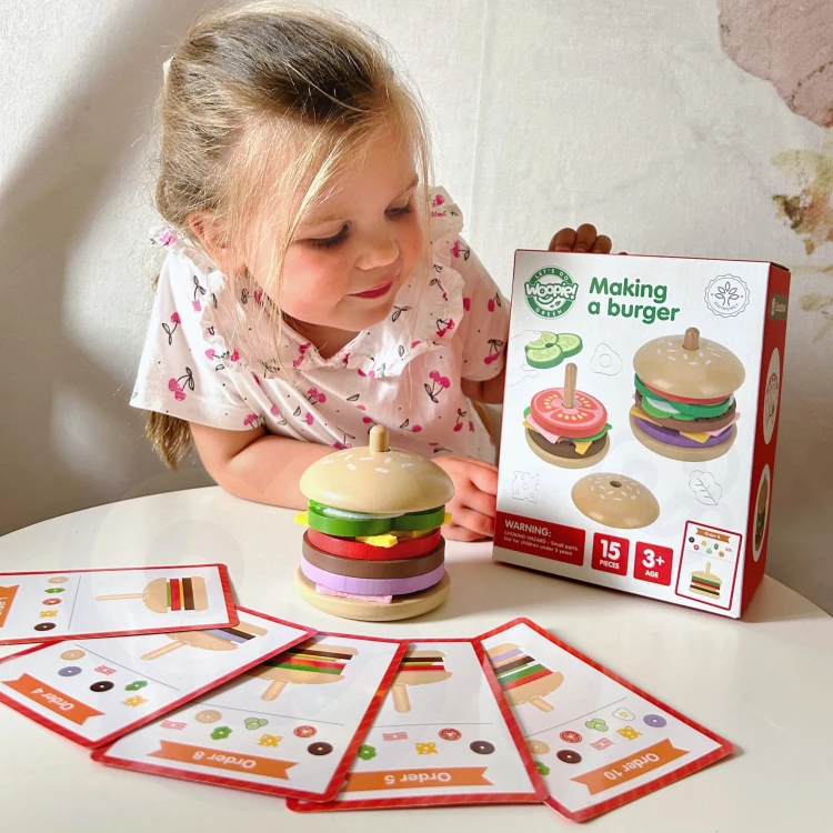 Zbliżenie na drewniane elementy burgera — bułka, ser i warzywa z wyraźnymi kolorami i fakturą