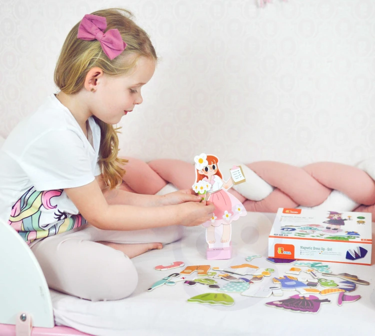 Dziecięce dłonie zakładają ubranie na drewnianą laleczkę — pokaz zastosowania układanki edukacyjnej VIGA