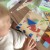 Ręka układa elementy Tangram TOOKY TOY — demonstracja zabawy i łączenia kształtów w obrazki