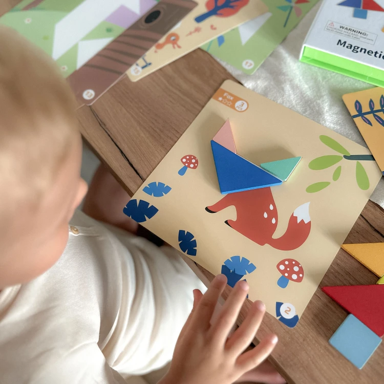 Ręka układa elementy Tangram TOOKY TOY — demonstracja zabawy i łączenia kształtów w obrazki