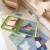 Widok z góry na rozsypane elementy Puzzle Tangram 18el. TOOKY TOY — zestaw do ćwiczeń rozpoznawania kształtów