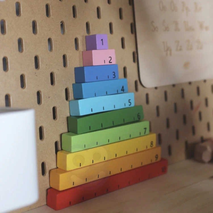 Dziecko bawi się liczydłem, przesuwa koraliki i uczy się liczb z pomocą pudełka Montessori