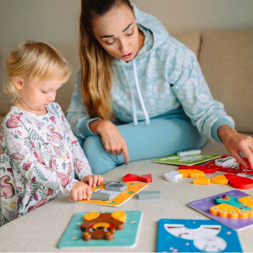 Widok z góry na klocki WOOPIE GREEN — rozsypane zwierzątka drewniane i elementy montessori na stole