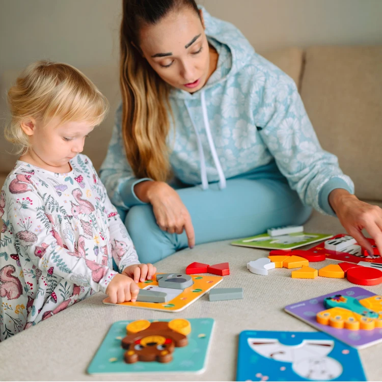 Widok z góry na klocki WOOPIE GREEN — rozsypane zwierzątka drewniane i elementy montessori na stole
