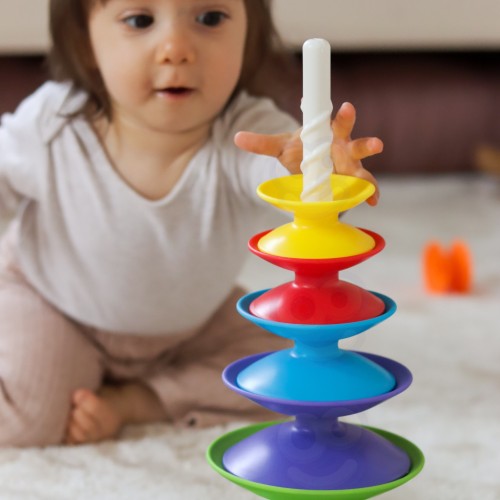 Widok z góry na piramidkę WOOPIE BABY — rozłożone kolorowe krążki w przejrzystym układzie, kontrastujące barwy