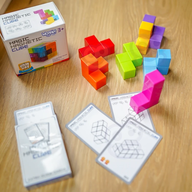 Ręce układające kostkę Tetris zgodnie z kartą z zadaniem — praktyczne użycie układanki i zabawa edukacyjna