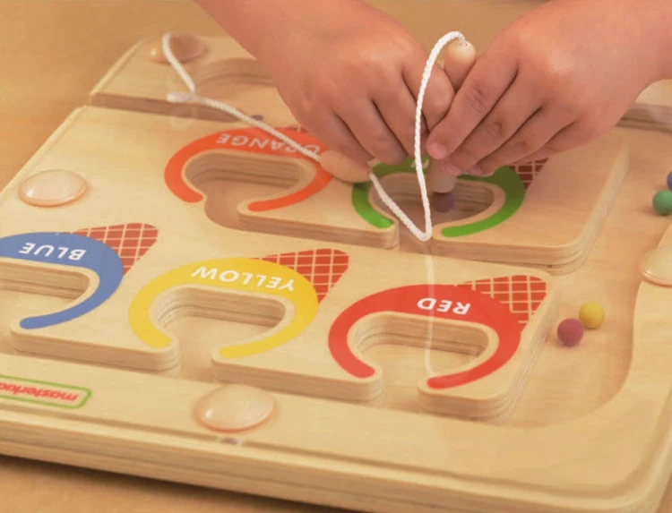 Dziecko bawiące się labiryntem magnetycznym MASTERKIDZ — chwyt i przesuwanie kolorowych elementów na stole